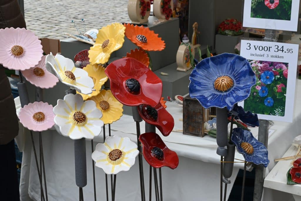 Op de foto staan gekleurde bloemen in keramiek tijdens de Keramiekdagen in Gouda.